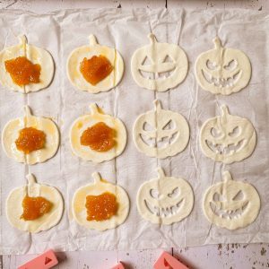 Jeweils eine Hälfte Blätterteigkürbisse mit Gesicht und mit Marmelade