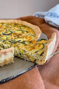 Ein Stück Zucchini Quiche auf einer Kuchengabel