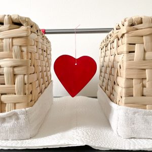 Ein Modellierherz aufgehangen ein einem Stift zwischen zwei Boxen