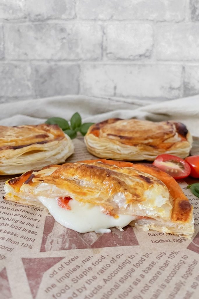 Aufgeschnittener Rustico auf Backpapier mit herauslaufender Füllung