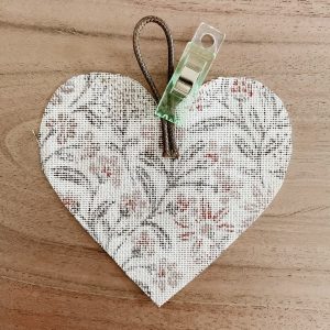 Lederband an einem Stoff-Herz mit einem Clip befestigt