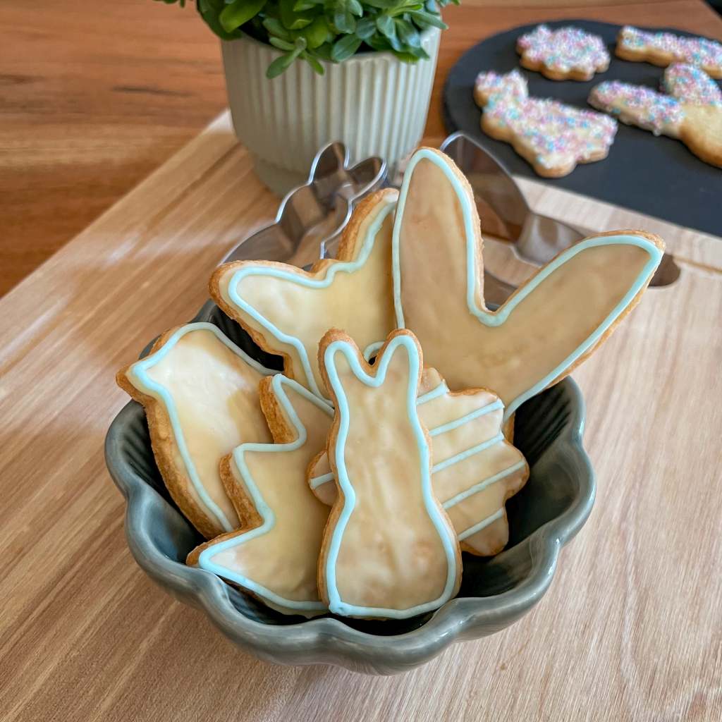 Osterplätzchen mit weißer Schokolade und blauer Zuckerschrift verziert