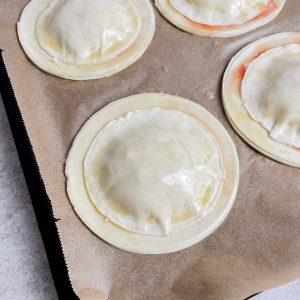 Kleine Blätterteigkreise aufgelegt und mit Eigelb eingepinselt