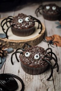 Drei Spinnenmuffins auf einem Holztisch